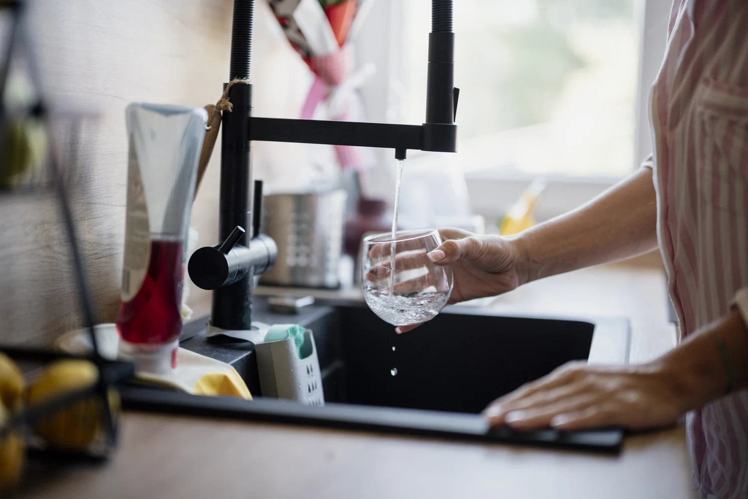 Water flowing from a kitchen tap into a glass