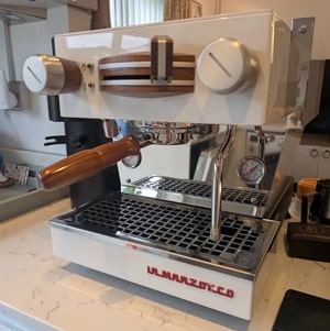 La Marzocco Linea Micra in white with wood accents on a kitchen counter