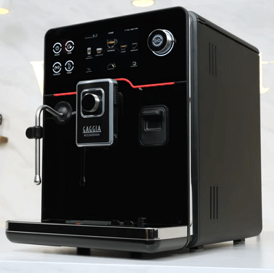 Gaggia Accademia super-automatic espresso machine with metal body and milk carafe.