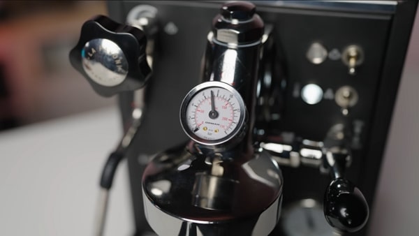 Close-up of the Mini Cellini boiler pressure gauge near the E61 group.