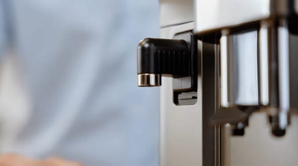 Close-up of the De’Longhi Magnifica Evo milk spout connection on the machine